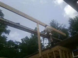 Carpenter setting a ridge beam over a new addition frame — Ice Dam Removal by Roofing Brothers in Coventry