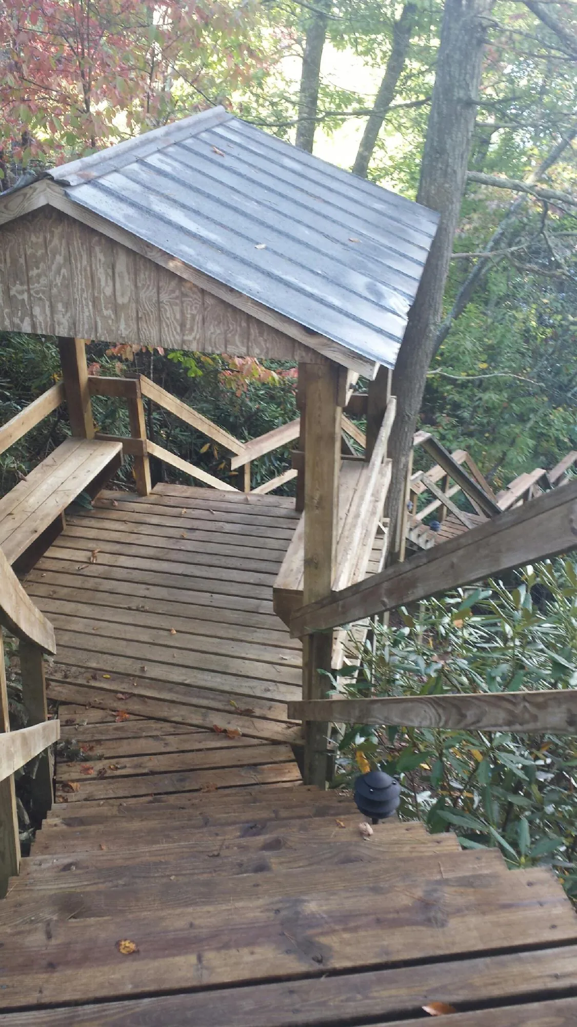 Metal roofed shelter over wooden steps on a wooded walkway — Skylight Repair & Installation work by our crew in Coventry